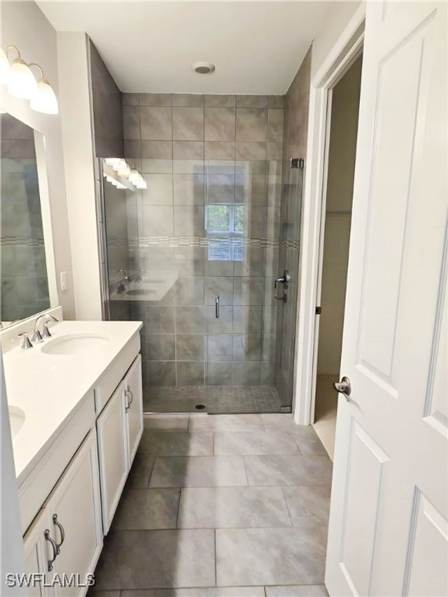 Full bath with double vanity, a stall shower, and tile patterned floors | Image 8