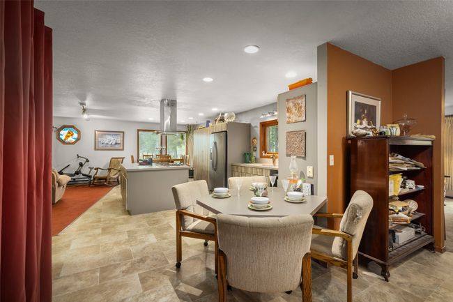 Dining room with a textured ceiling, recessed lighting, and stone finish floors | Image 21