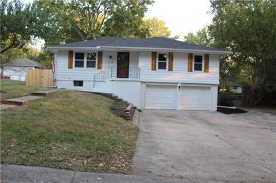 View of front facade with a garage and a front lawn | Image 1