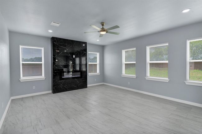 Unfurnished living room with a ceiling fan and recessed lighting | Image 9