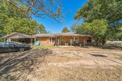 Ranch-style house with covered porch and a carport | Image 1