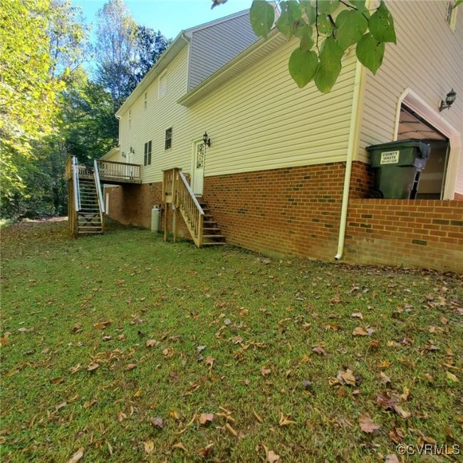 View of side of property with stairway, a wooden deck, and a yard | Image 4