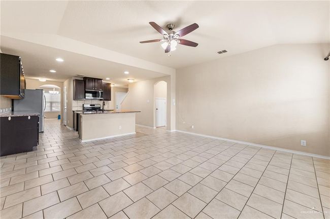 Unfurnished living room featuring arched walkways, ceiling fan, lofted ceiling, and recessed lighting | Image 10