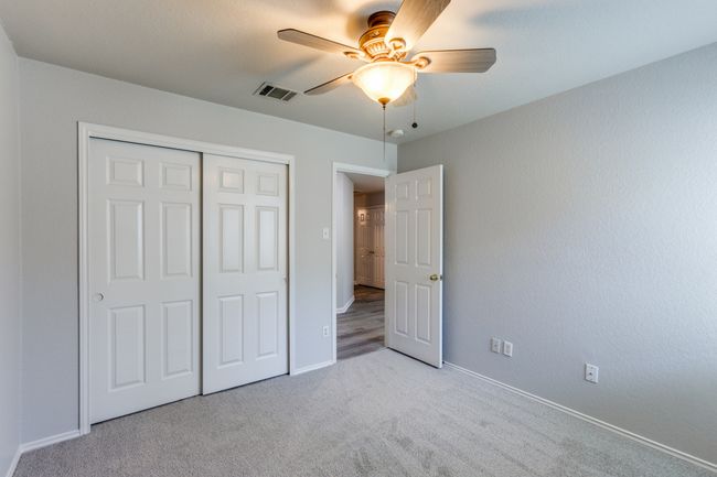 Bed #1 Unfurnished bedroom featuring light colored carpet, a closet, and a ceiling fan | Image 22