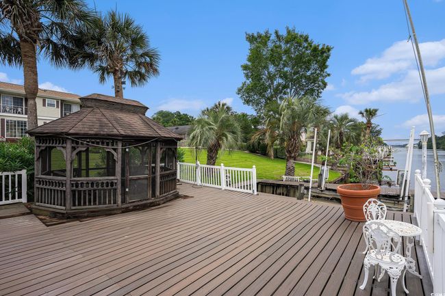Wooden terrace with a gazebo, a water view, and a yard | Image 36