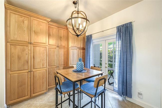 Dining area with french doors, a chandelier, and light tile patterned floors | Image 9