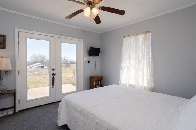 Bedroom featuring french doors, access to outside, carpet, ornamental molding, and ceiling fan | Image 21