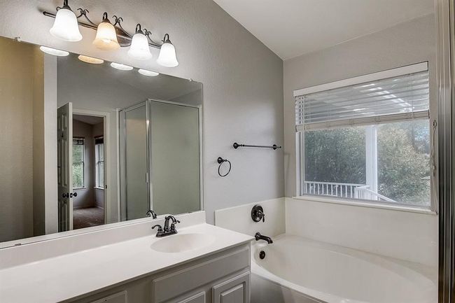 Full bath featuring a garden tub, vanity, and a stall shower | Image 23