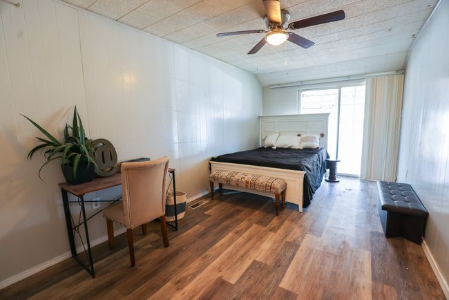 Bedroom with ceiling fan, wood finished floors, and baseboards | Image 16