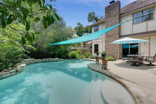 View of pool featuring a patio and lush greenery | Image 5