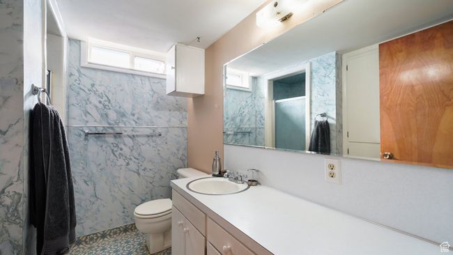 Bathroom featuring vanity, toilet, and a shower with shower door | Image 20