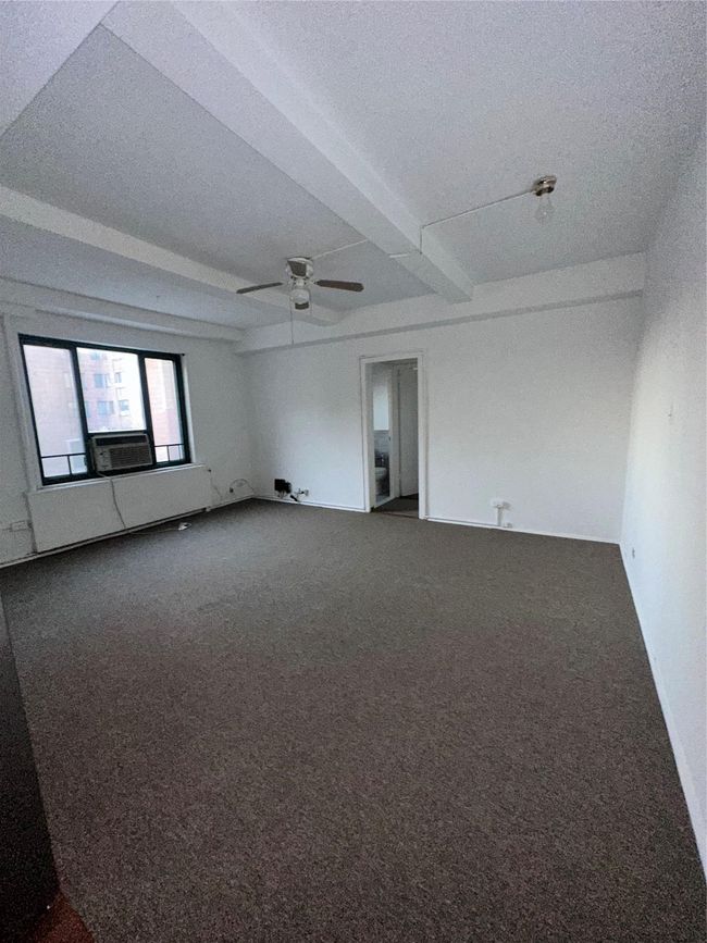 Spare room with dark colored carpet, cooling unit, and ceiling fan | Image 11