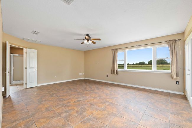 Empty room with a ceiling fan and baseboards | Image 10