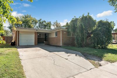 Ranch-style home featuring a garage, a front lawn, and a carport | Image 2