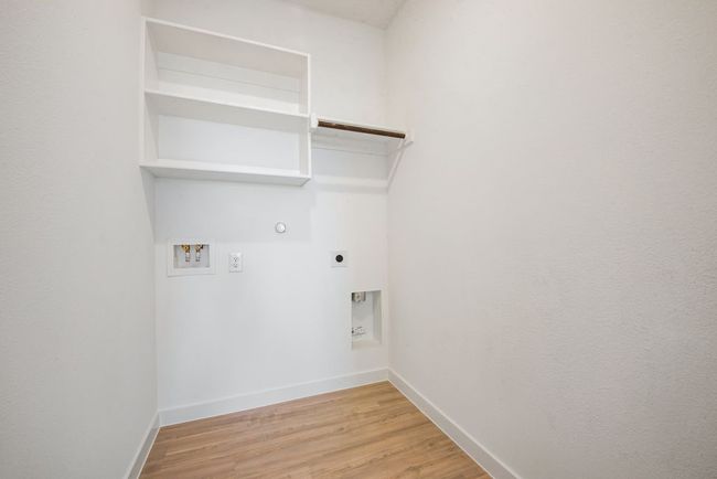 Washroom with hookup for an electric dryer, hookup for a washing machine, gas dryer hookup, and light wood-style flooring | Image 10