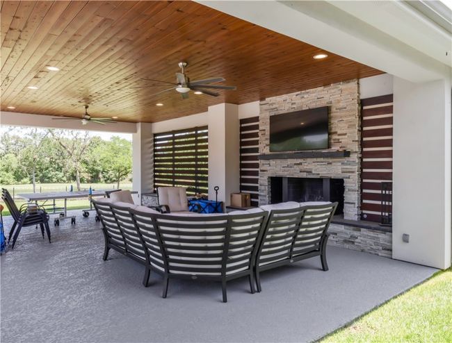 View of patio with an outdoor living space with a fireplace and ceiling fan | Image 9