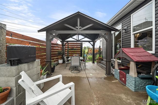 Fenced backyard with a gazebo, outdoor dining space, and a patio area | Image 43