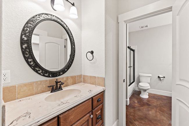 Bathroom featuring vanity, toilet, enclosed tub / shower combo, and baseboards | Image 27