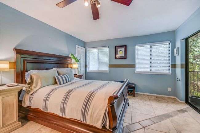 The primary suite captures the treehouse aesthetic perfectly with numerous windows and sliding glass doors providing private balcony access. | Image 6