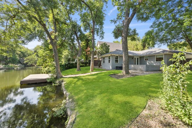 View of the Rear of Home Situated on a Creek Lot with Large Back Yard, Designated Patio, Towering Mature Trees and Wood Dock | Image 10