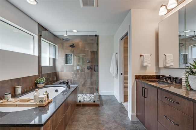 The primary ensuite bathroom serves as your daily spa getaway with a deluxe jetted soaking tub, luxury walk-in shower, and spacious dual vanity with custom contemporary cabinetry. | Image 8