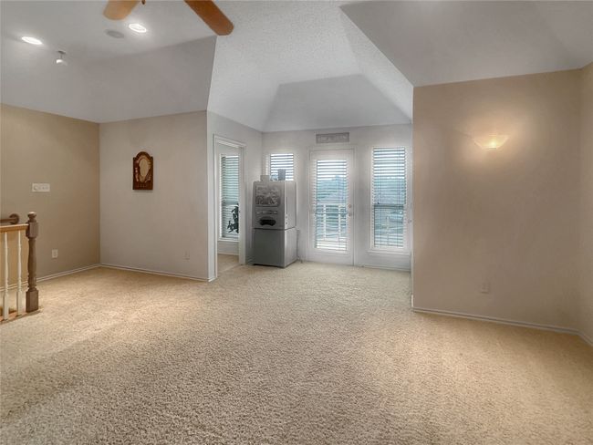 Empty room featuring light colored carpet, baseboards, ceiling fan, and vaulted ceiling | Image 21