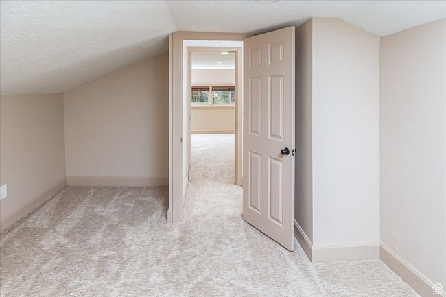 Additional living space featuring carpet flooring, a textured ceiling, and lofted ceiling | Image 34