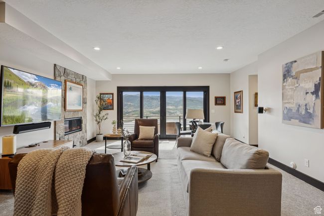 Living area with light carpet, a fireplace, and recessed lighting | Image 44