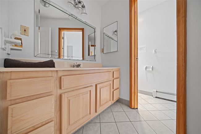 Bathroom with a baseboard radiator, baseboards, vanity, and tile patterned floors | Image 33