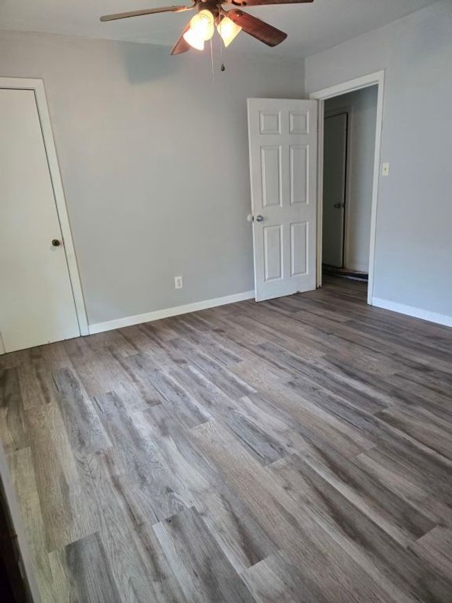 Unfurnished bedroom with wood finished floors and a ceiling fan | Image 17