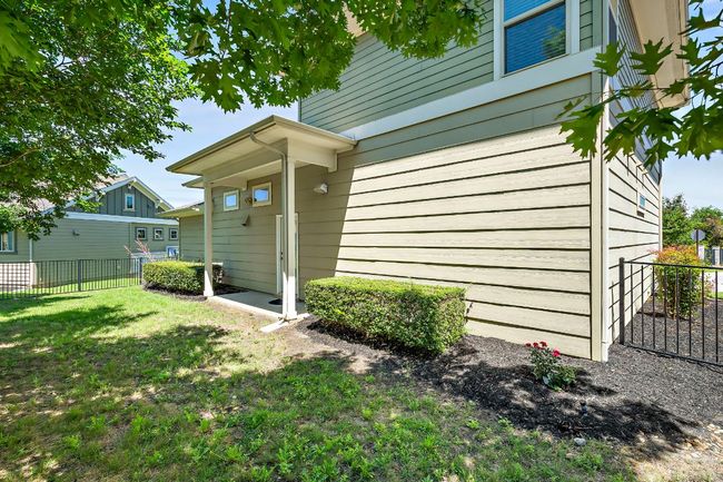 View of exterior entry with a lawn and fence | Image 29