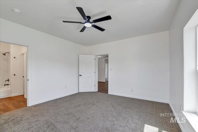 Unfurnished bedroom featuring carpet flooring, ensuite bathroom, and ceiling fan | Image 18
