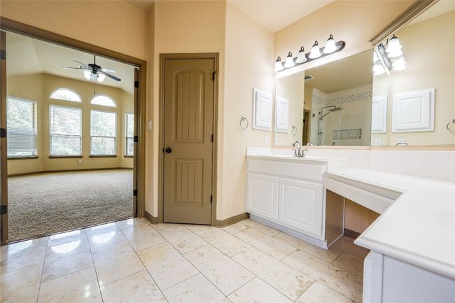 Full bathroom featuring a ceiling fan, vanity, a shower, and lofted ceiling | Image 38