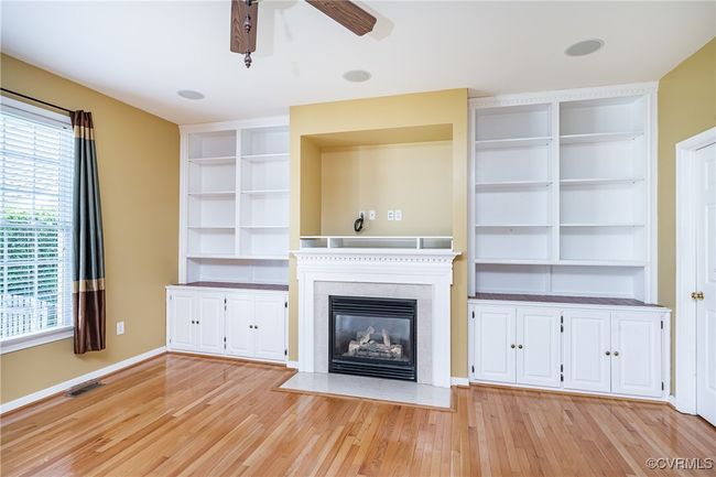 Unfurnished living room with ceiling fan, plenty of natural light, and light wood-style floors | Image 16