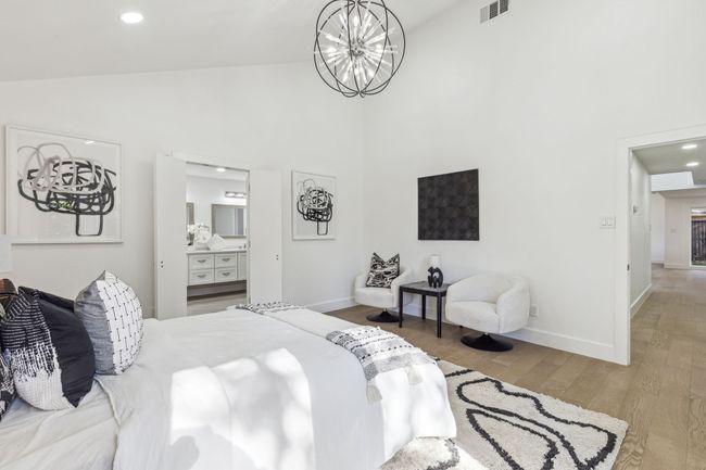 Bedroom with visible vents, baseboards, a chandelier, wood finished floors, and high vaulted ceiling | Image 21