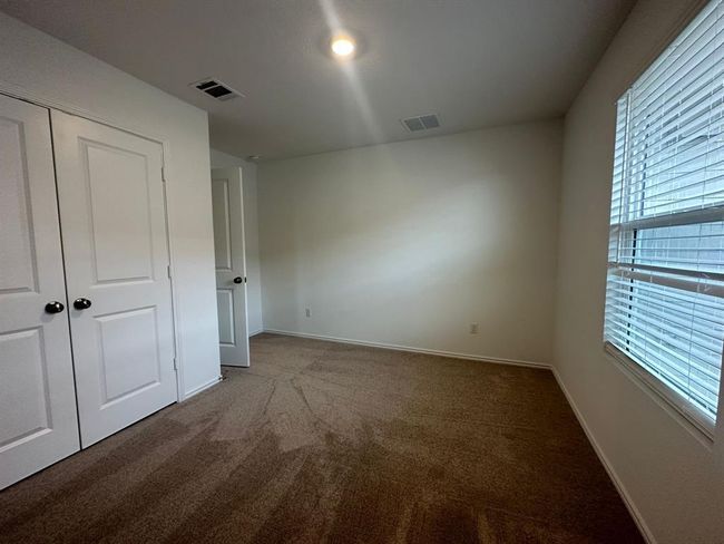 Unfurnished bedroom with carpet flooring, multiple windows, baseboards, and a closet | Image 18