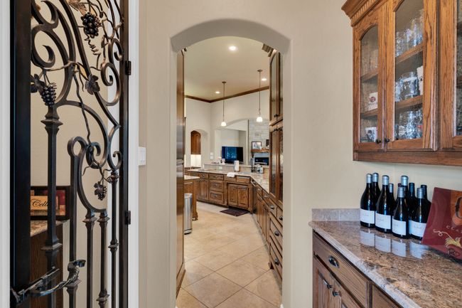 Bar with arched walkways, light tile patterned flooring, hanging light fixtures, and crown molding | Image 15