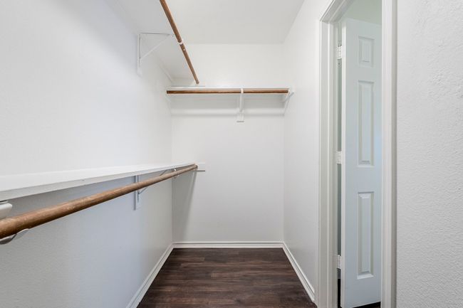 Walk in closet featuring dark wood-type flooring | Image 19