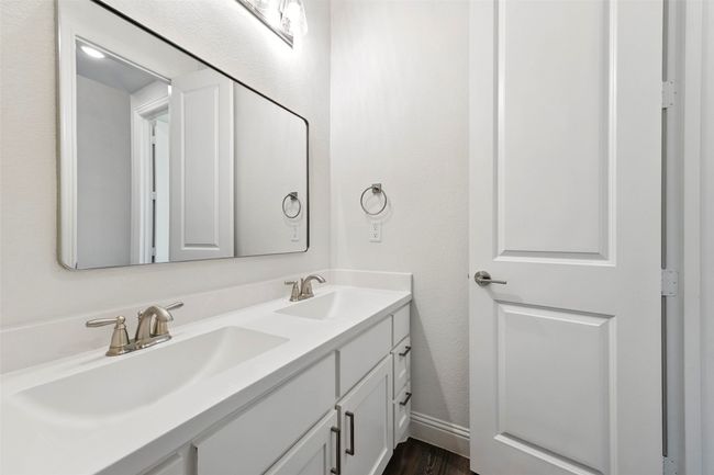 Bathroom with double vanity, a textured wall, and tile floors | Image 27