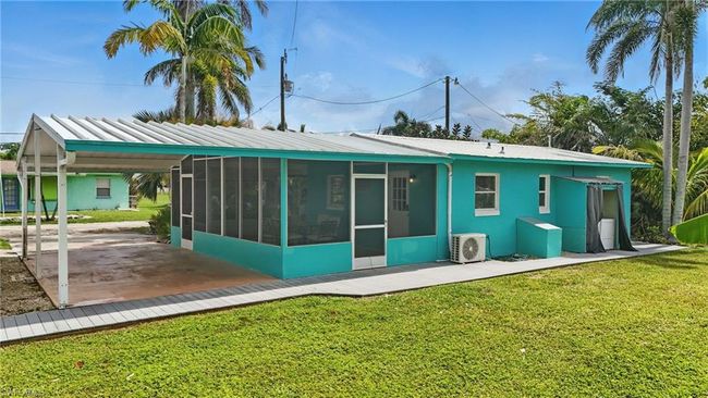 Rear view of property with a sunroom, a yard, and a metal roof | Image 32