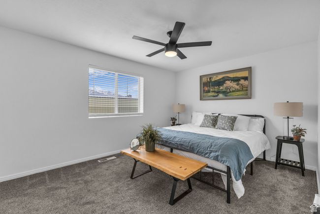 Carpeted bedroom featuring baseboards, a ceiling fan, and visible vents | Image 5