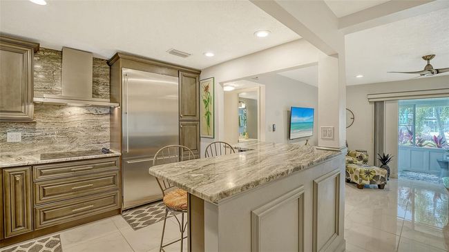 Open kitchen with abundant countertops and Gaggenau refrigerator, oven and Bosch dishwasher. | Image 15