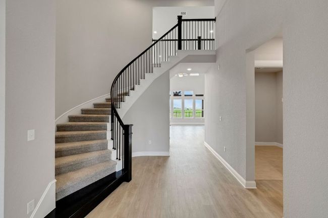 Staircase with a towering ceiling and wood finished floors | Image 4