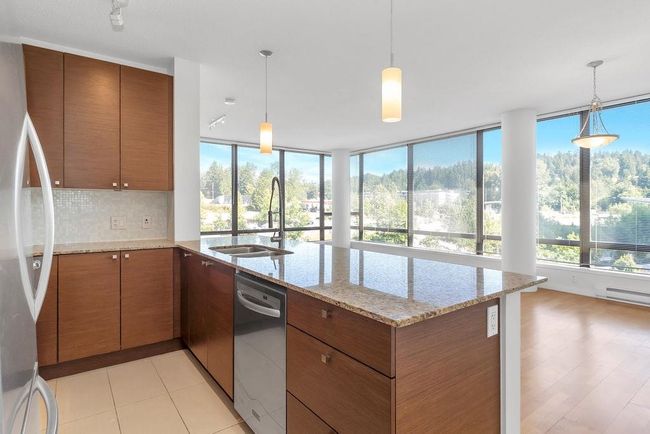 Kitchen featuring stainless steel appliances, a peninsula, brown cabinets, and tasteful backsplash | Image 5