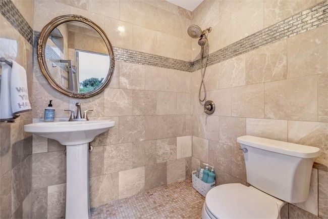Full outdoor wet bathroom with hot-water shower, sink, toilet, and floor to ceiling Italian marble tile. | Image 36