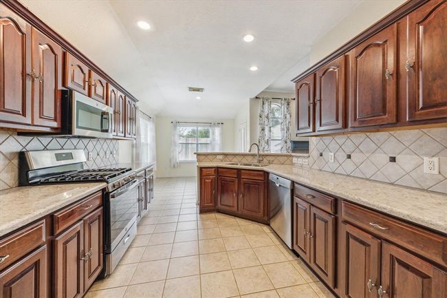 Kichen showing plenty of counter space, lovely wood cabinets, and quartzcountertops. | Image 6