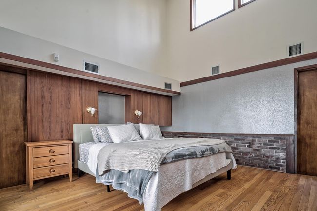 Bedroom featuring a high ceiling and light wood finished floors | Image 12