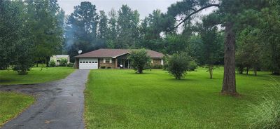 This is a single-story, brick-front home with a one-car garage and a well-maintained lawn, set in a neighborhood with mature trees. | Image 3