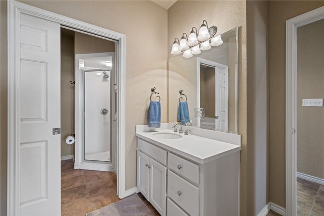Bathroom with tile patterned floors, a shower stall, vanity, and baseboards | Image 21