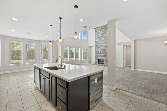 Kitchen with visible vents, open floor plan, dishwasher, and a sink | Image 17